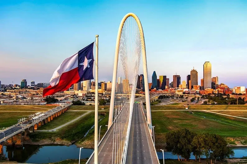 A texas flag flies over a bridge in dallas, texas.