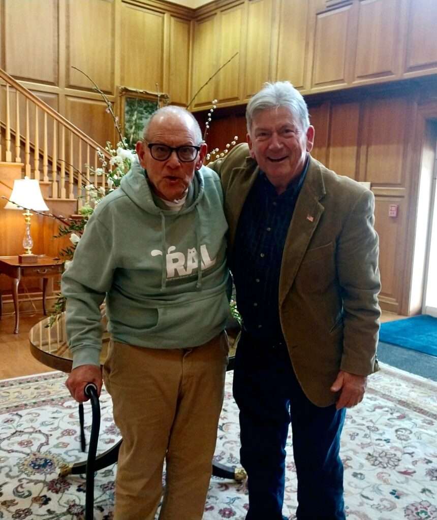 Two men standing next to each other in a room.