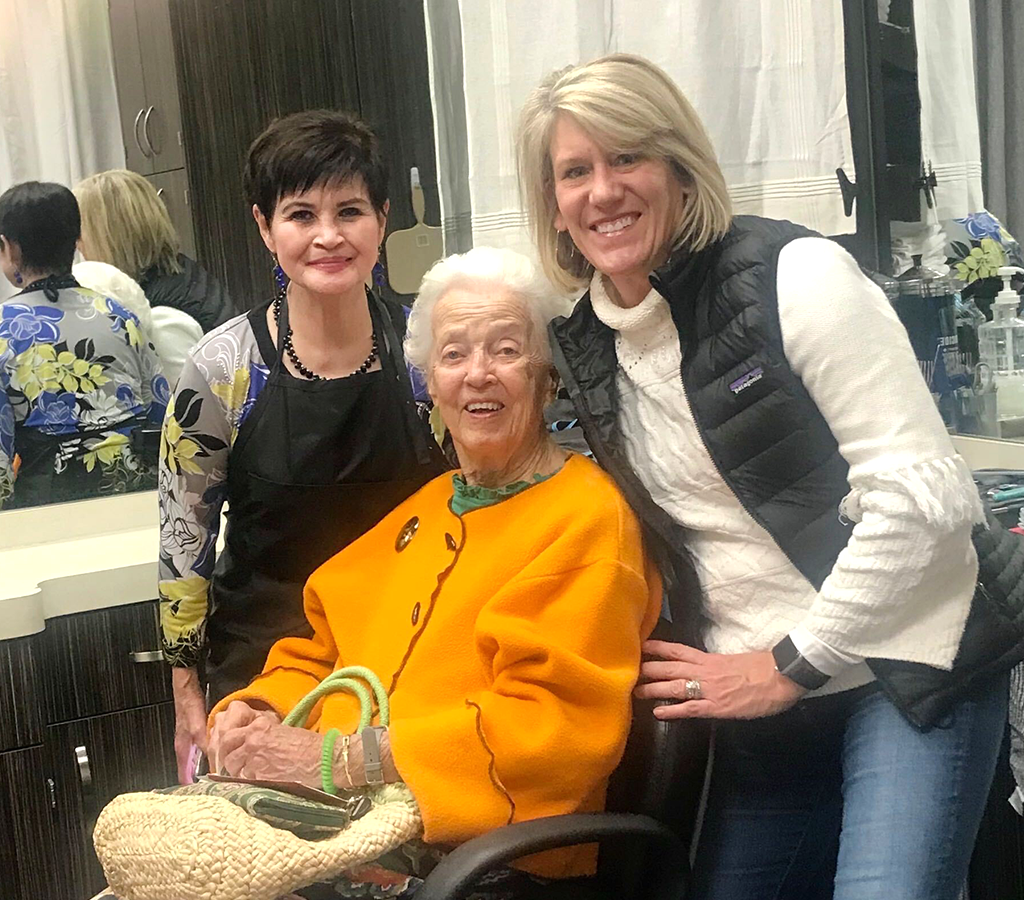 Three women posing with an older woman in a chair.